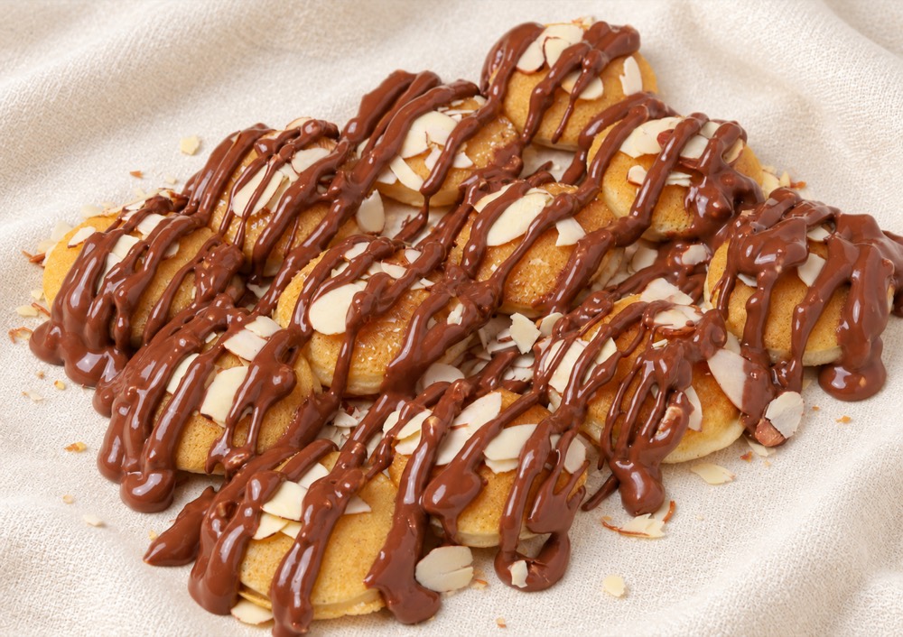 Assiette de mini pancakes nappés de chocolat et d’amandes effilées